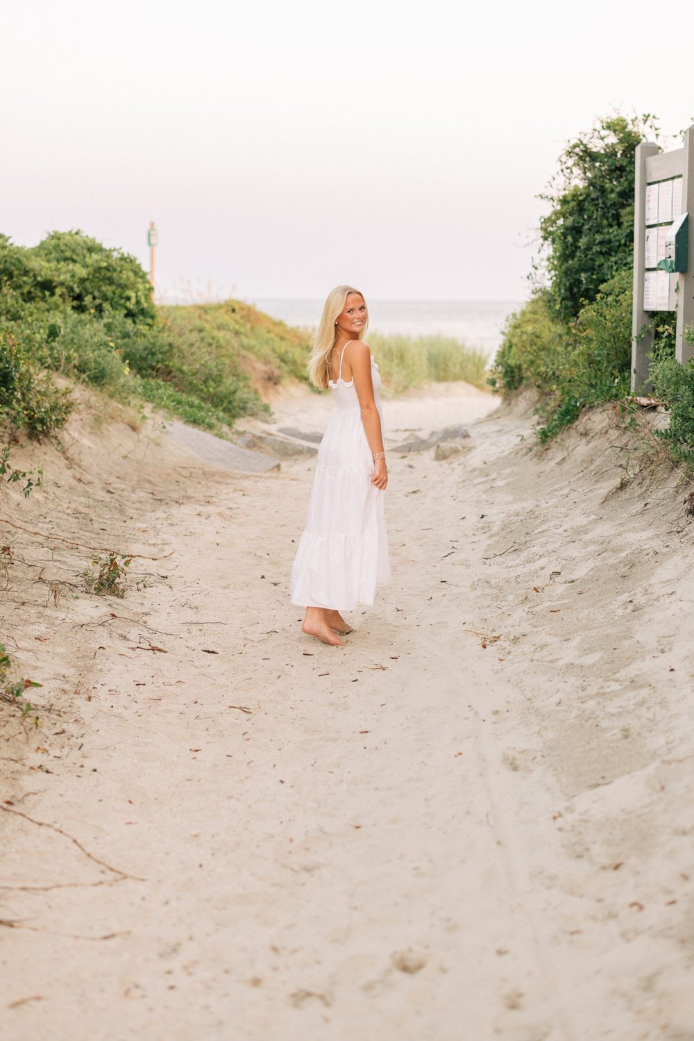 Ayla Adorno on a beach path in a white sundress
